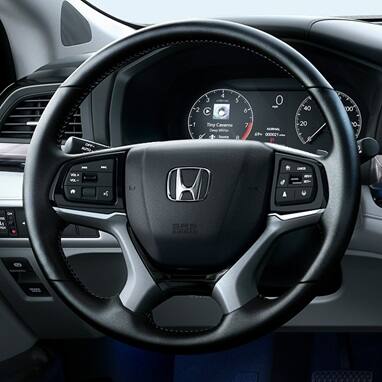 Honda Odyssey steering wheel with mounted controls and digital instrument cluster (Minivan).