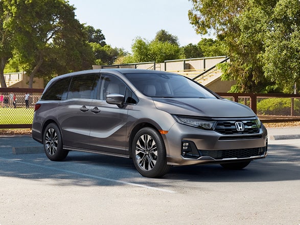 Front view of the 2027 Honda Odyssey minivan Elite in Modern Steel Metallic parked outdoors (Minivan).